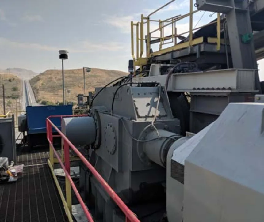 Mining crusher gearbox and conveyor on a hillside site, the asset whose oil was monitored after a routine oil change - Miniotec