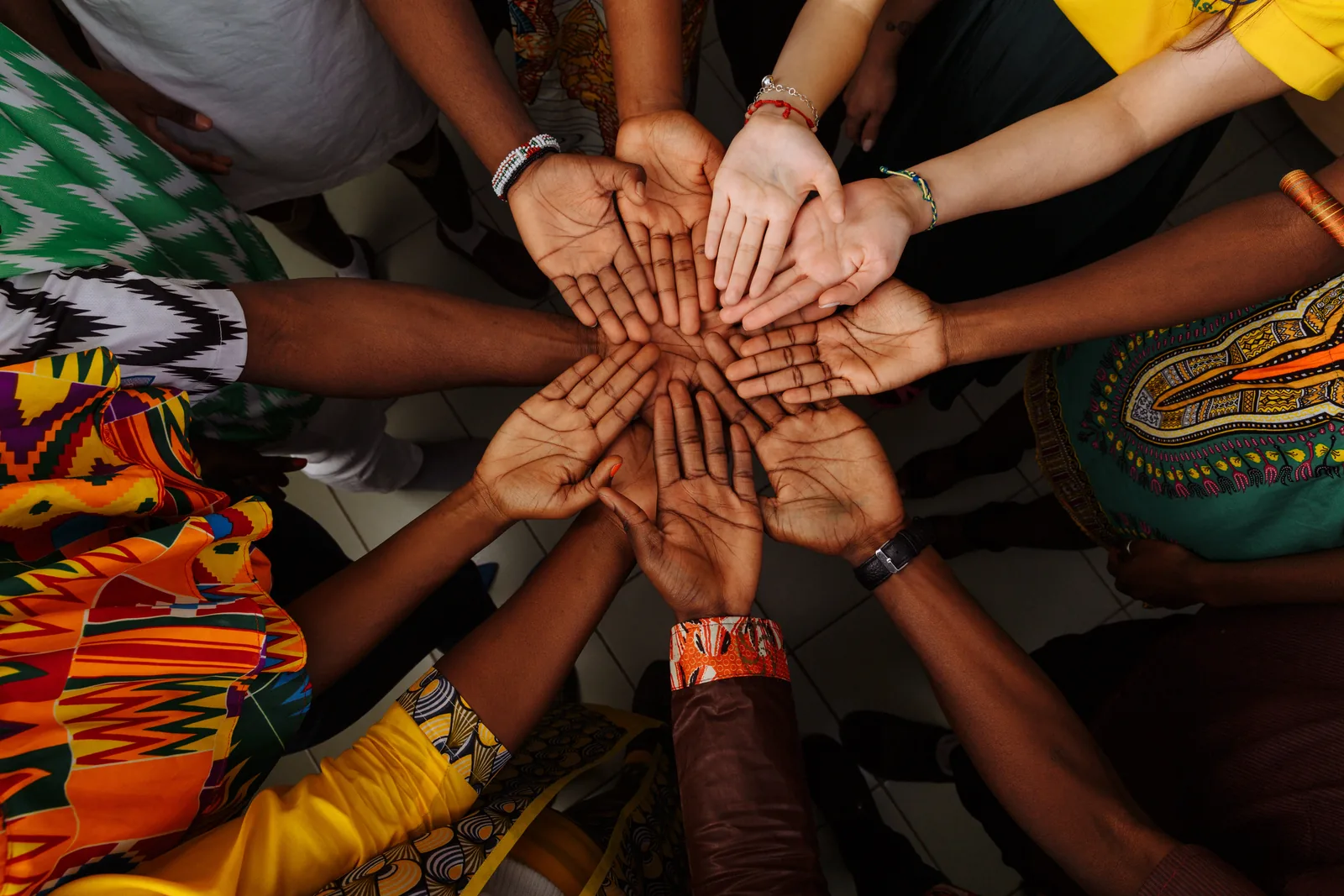 A group of hands joined together, representing Miniotec's commitment to a diverse, equitable and inclusive workplace
